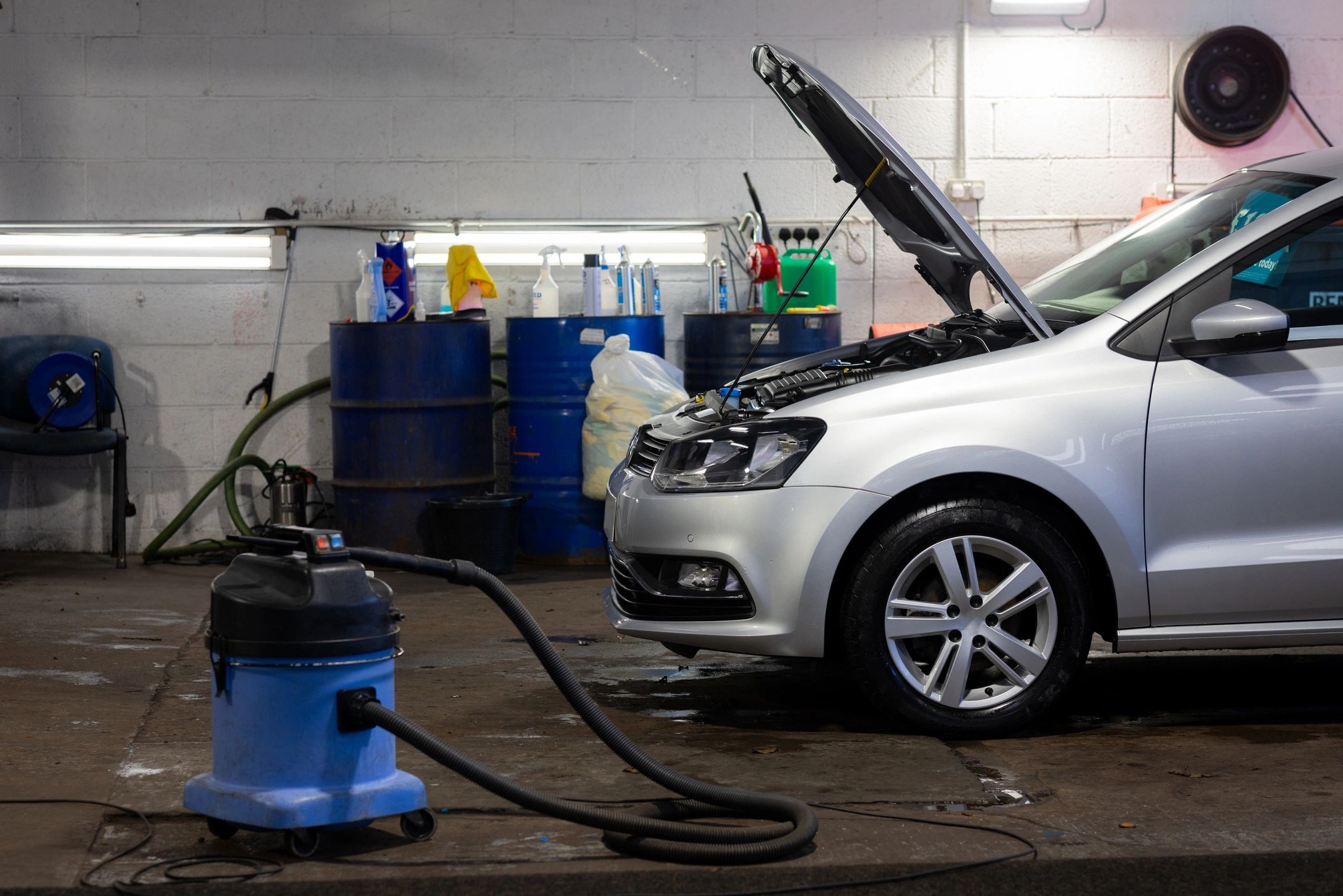 Vehicle being serviced in a garage with the hood open